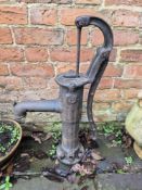 A cast iron water pump garden or pond feature.