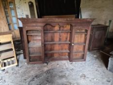 An antique pine dresser having central shelves flanked by glazed doors a/f.