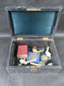 A vintage leather covered jewellery box containing a quantity of collectables including religious