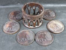 A set of carved hardwood coasters with elephant theme.