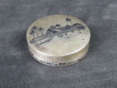 A delightful white metal compact having North African scene upon and mirror within.