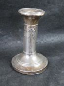 A delightful hallmarked silver short candlestick having relief decoration thoughout.