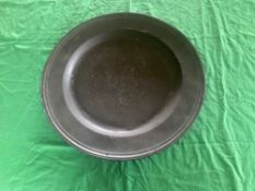 A large and impressive antique pewter charger plate having makers marks upon and measuring 52cm dia.