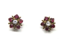 A pair of 9ct gold diamond and ruby floral stud earrings, hallmarked 375 to the post,