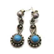 A pair of handmade turquoise earrings.