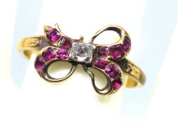 An antique 18ct gold ring in the form of a bow, a/f, set with diamond and rubies,