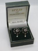 A pair of silver earrings in presentation box.