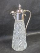 A glass claret jug with silver plated lid.