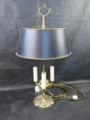 A brass table lamp with rise and fall shade.