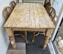 A pine kitchen table 128 x 87 x 75cm, with four wheel back dining chairs.