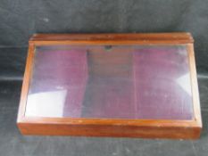 A tabletop display case, lined in purple velvet.