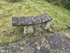 A garden bench comprising two pedestals and curved top.