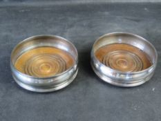 A pair of silver plated wine coasters.