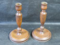A pair of turned wooden candlesticks.