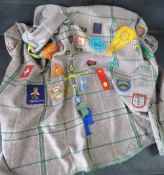 A Scouts blanket having various patches sewn upon.