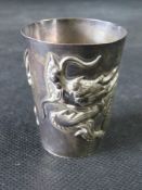 A delightful Chinese white metal tot cup having dragon in releif upon, character marks to base, 41.