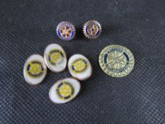 A pair of Rotary Club cufflinks, two pins and a sticker.