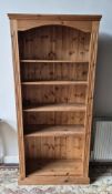 A tall contemporary pine bookcase with drop in shelves.