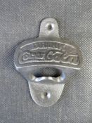 A contemporary cast iron bottle opener 'Drink Coca-Cola'.