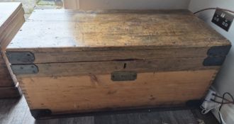 A large pine blanket box having cast iron bracing and end handles, brass front plate for 'D.