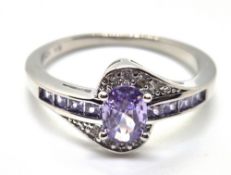 A silver ring set with purple and white