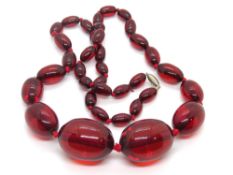 A red bead necklace, individually knotted beads.