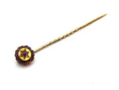 A yellow metal tie pin set with garnet and diamond floral pattern, indistinct stamp, 1.3g.