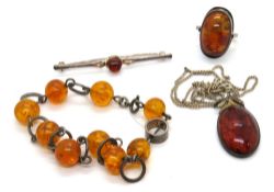 Four pieces of amber jewellery including silver ring and silver pendant on chain,