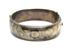 A hallmarked silver bangle having foliate engraving to front.