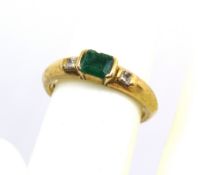 An emerald and diamond ring, the central transverse set rectangular cut emerald approx 4.2 x 5 x 2.