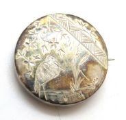 A white metal brooch having heron design engraved upon, 3.3cm dia.