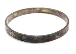 A silver bangle having Chester hallmark and foliate engraving throughout, worn condition, 6.5cm dia.