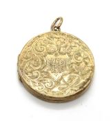 A vintage yellow metal locket, no apparent hallmarks, engraved foliate decoration to both sides, 2.