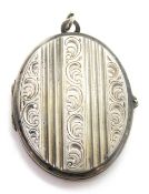 A large white metal locket having floral