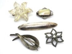 Three silver brooches and two white metal brooches.