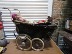 A Victorian style dolls pram, leather supports a/f, containing a quantity of dolls.