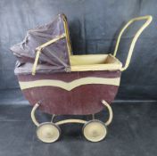 A vintage dolls pram featuring a distinct two-tone colour scheme and a folding hood.