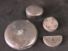 A quantity of white metal pill pots and a compact.