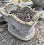 A concrete planter in the form of a wagon.
