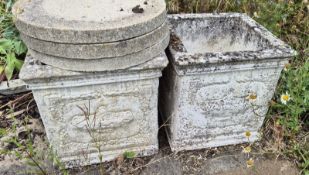 A pair of square shaped concrete planters.