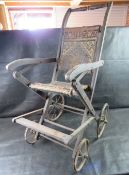 A late 19th early 20th century wooden child's wheelchair or stroller,