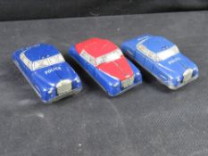 Three tin clockwork toy cars.