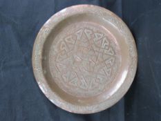 A substantial Persian influenced copper dish 30cm diameter.