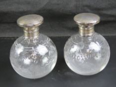 A pair of cut glass and hallmarked perfume bottles, lids a/f.