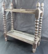 A vintage carved oak umbrella stand with drip tray