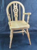 A contemporary child sized pine wheel back carver chair