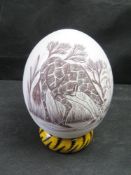 A vintage hand-etched Ostrich egg featuring a detailed giraffe scene.