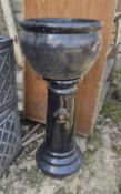 A black glazed plant pot with pedestal.