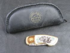 A Franklin Mint collector's pocket knife having scene of two black Labrador dogs on the handle.