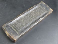 A hand carved wooden double sided printing block with Tibetan script,